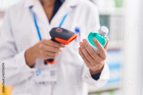 Young blonde woman pharmacist scanning medication bottle at pharmacy
