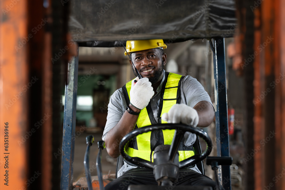 African American male worker driving forklift truck in heavy metal ...