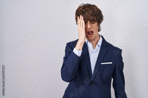 Hispanic business young man wearing glasses yawning tired covering half face, eye and mouth with hand. face hurts in pain.