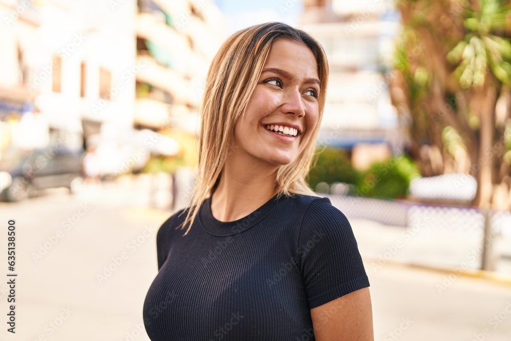 Young hispanic woman smiling confident looking to the side at street