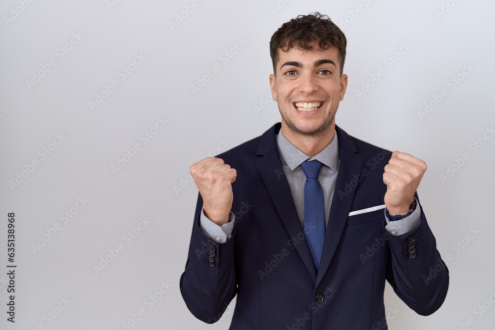Young hispanic business man wearing suit and tie celebrating surprised and amazed for success with arms raised and open eyes. winner concept. Young hispanic business man wearing suit and tie celebrating surprised and amazed for success with arms raised and open eyes. winner concept.