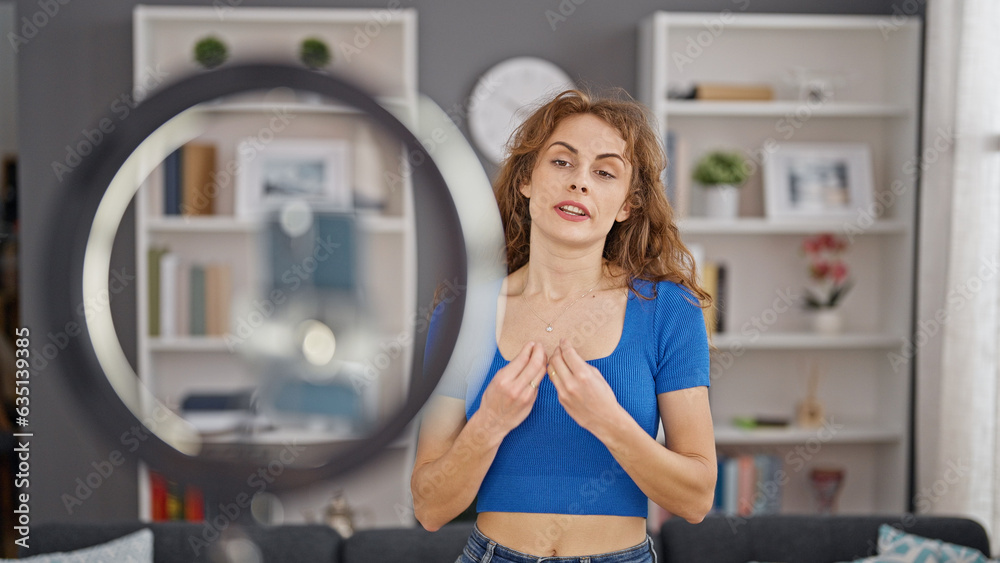 Young woman recording video tutorial speaking at home