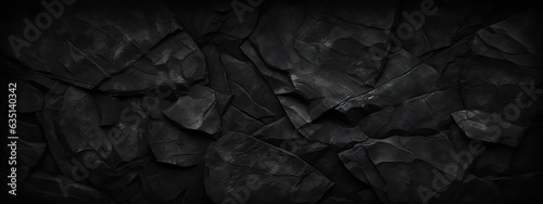 Volumetric rock texture with cracks. Black stone background with copy space for design. Wide banner. © Eli Berr