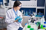 Young woman scientist writing on notebook at laboratory