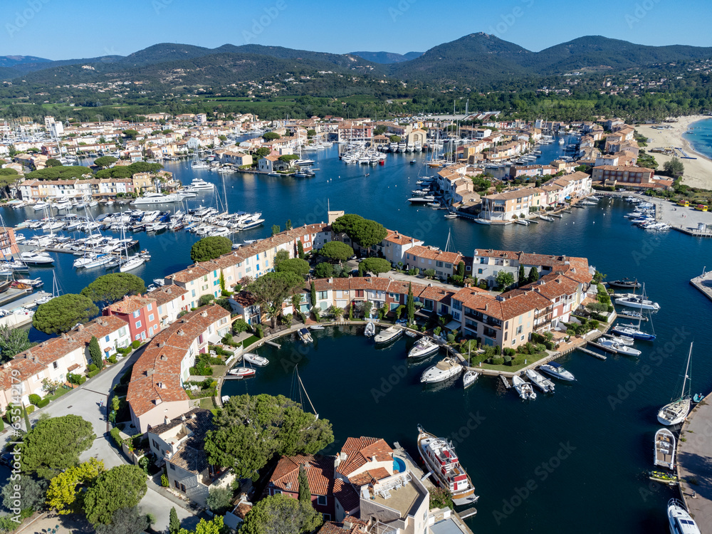 Arial view on blue water of Gulf of Saint-Tropez, boats, houses in Port Grimaud and Port Cogolin, villages on Mediterranean sea with yacht harbour, Provence, summer in France