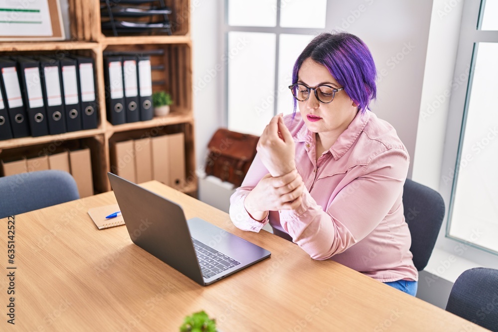 Young beautiful plus size woman business worker suffering for wrist pain working at office Young beautiful plus size woman business worker suffering for wrist pain working at office