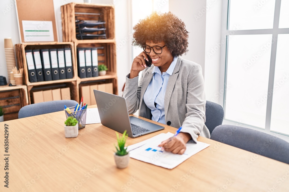 African american woman business worker talking on smartphone writing on document at office African american woman business worker talking on smartphone writing on document at office