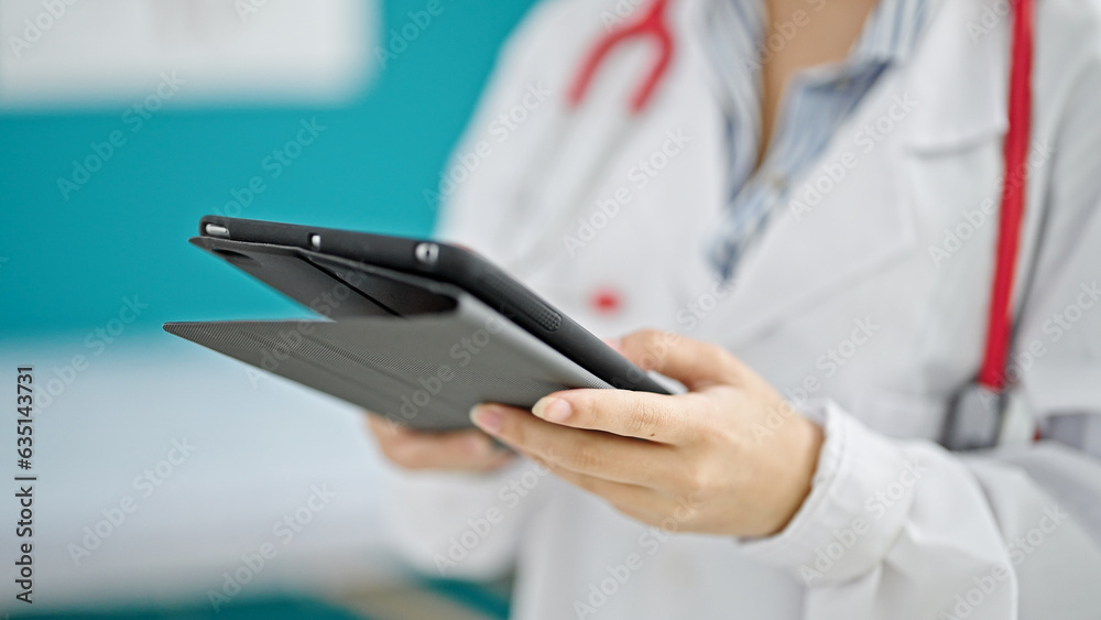 Young redhead woman doctor using touchpad at clinic Young redhead woman doctor using touchpad at clinic