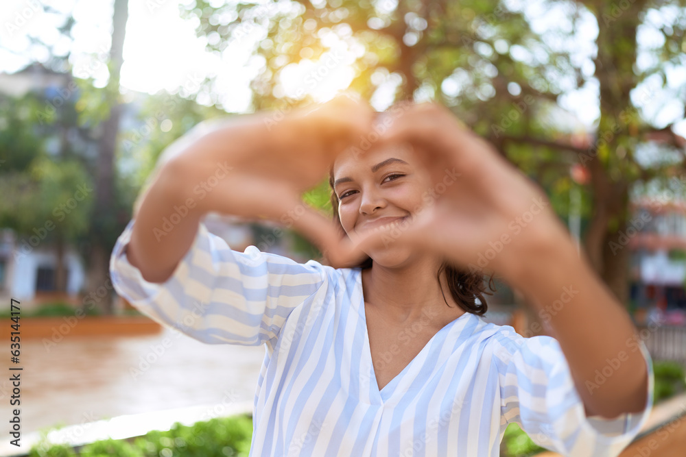 Young african american woman smiling confident doing heart gesture with hands at park