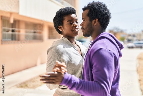 African american man and woman couple dancing at street