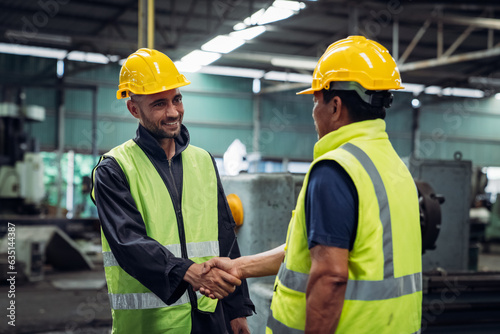 Team Engineer is shaking hands. Industrial worker in the factory. Engineer is maintaining in the warehouse.