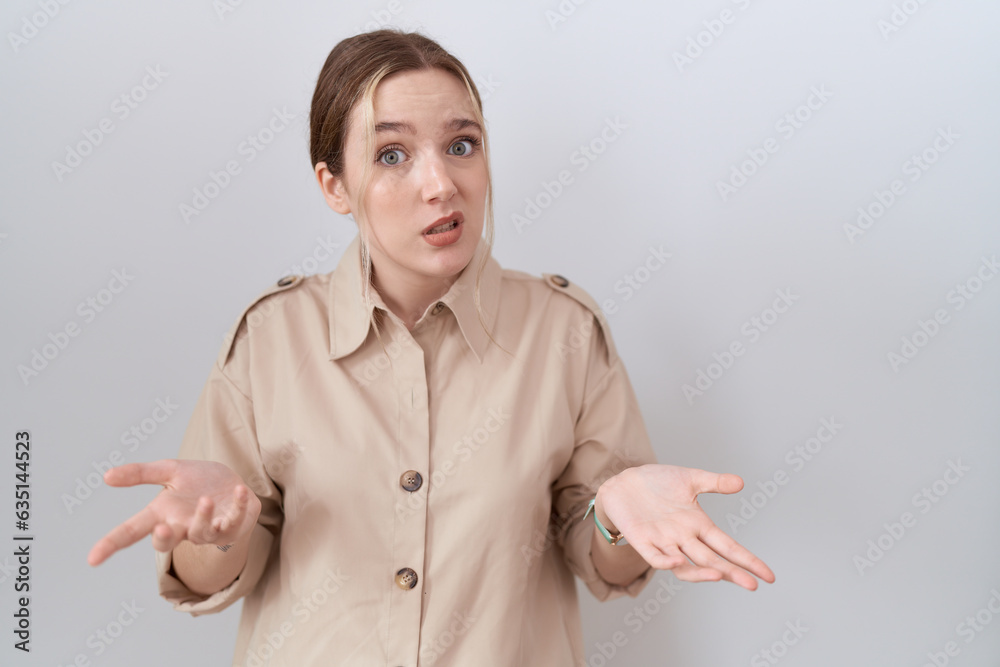 Young caucasian woman wearing casual shirt clueless and confused with open arms, no idea concept. Young caucasian woman wearing casual shirt clueless and confused with open arms, no idea concept.