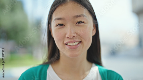 Young chinese woman smiling confident standing at street