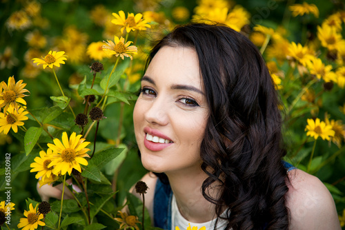 portrait of beautiful brunette smiling woman with yellow flowers