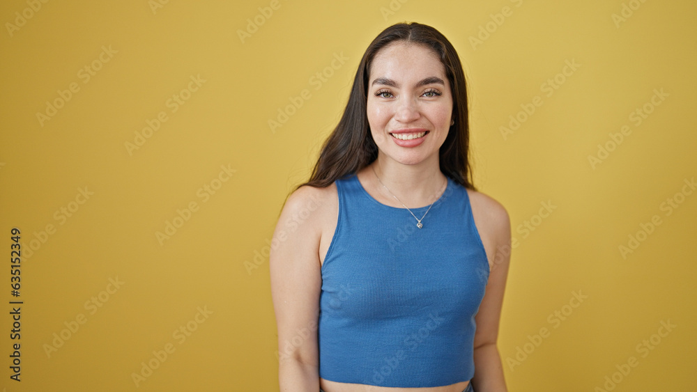 Young beautiful hispanic woman smiling confident standing over isolated yellow background Young beautiful hispanic woman smiling confident standing over isolated yellow background