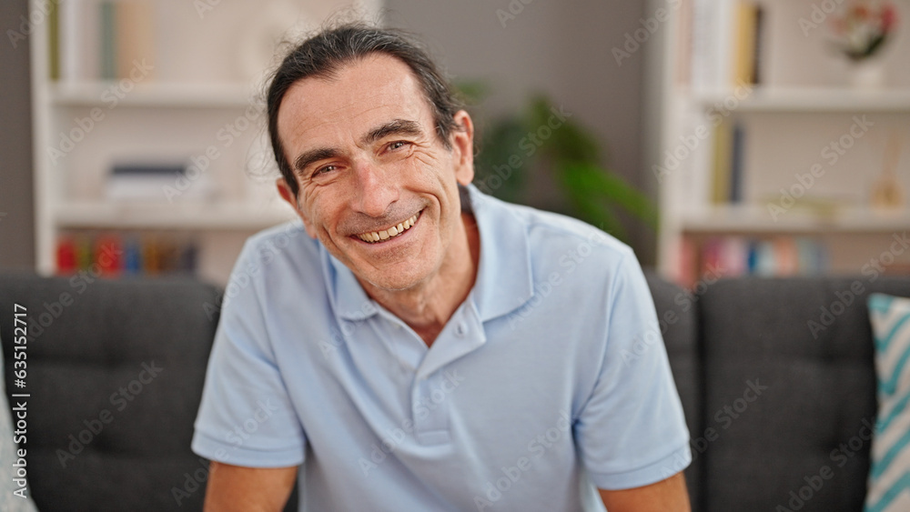 Middle age man smiling confident sitting on sofa at home Middle age man smiling confident sitting on sofa at home