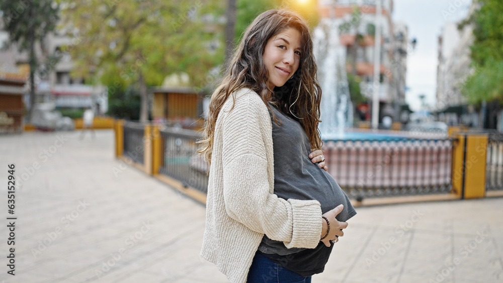 Young pregnant woman smiling confident touching belly at park Young pregnant woman smiling confident touching belly at park