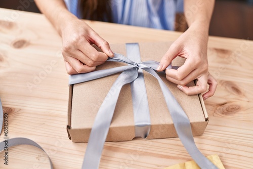Young beautiful hispanic woman ecommerce business worker prepare gift at office