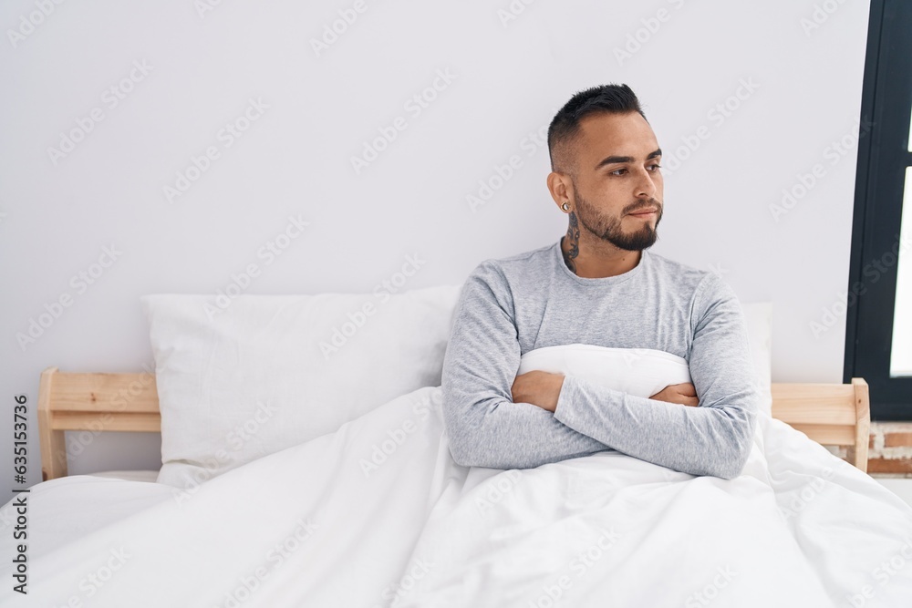 Young hispanic man lying on bed with serious expression at bedroom Young hispanic man lying on bed with serious expression at bedroom