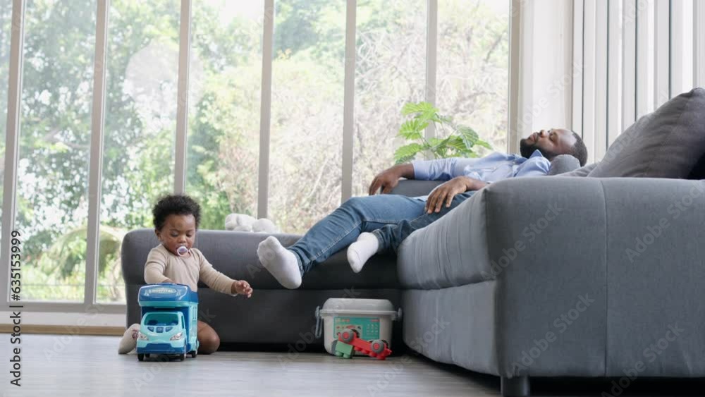 Happy Parents playing with a little infant toddler child on living room sofa. Parent and little kid relaxing at home. Parents and toddler child girl enjoying spending time at home. Childcare concept