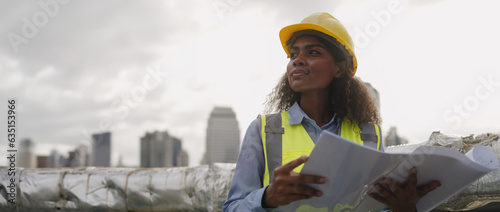 Civil engineer woman dark skin wearing uniform and safety helmet under inspection and checking plan on factory plant station by tablet.Civil Engineer,Industry,construction,Industry maintenance concept photo