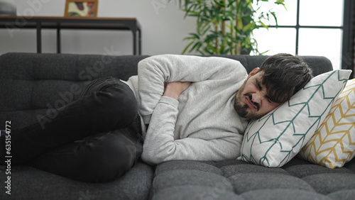 Young hispanic man suffering for stomach ache at home © Krakenimages.com