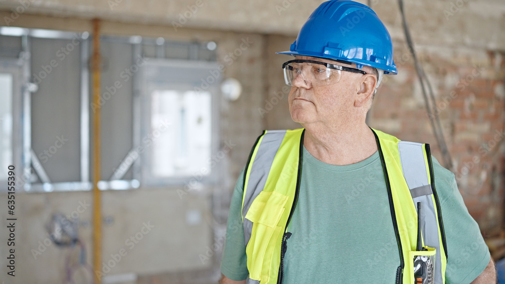 Middle age grey-haired man builder standing with relaxed expression at construction site Middle age grey-haired man builder standing with relaxed expression at construction site
