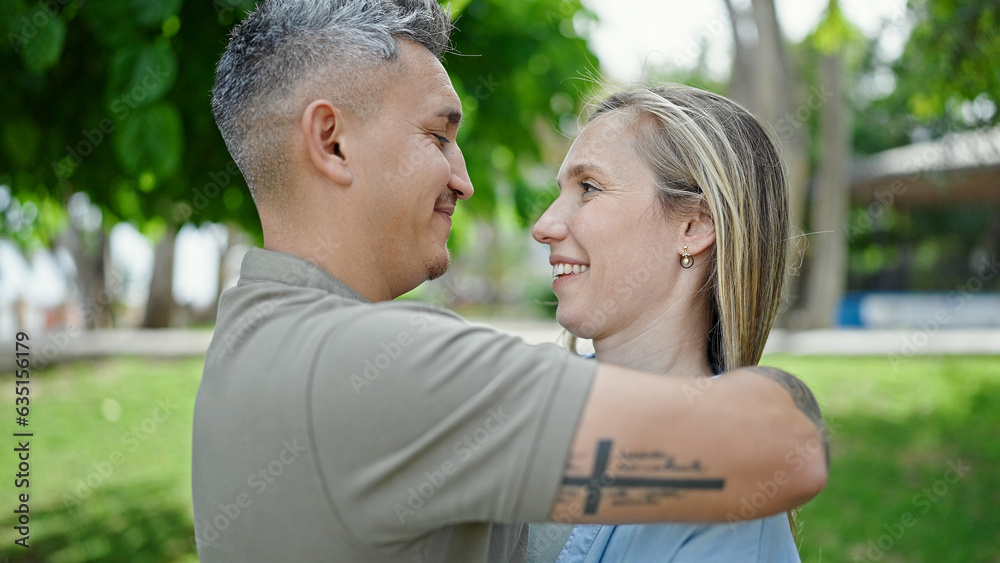 Man and woman couple hugging each other smiling at park