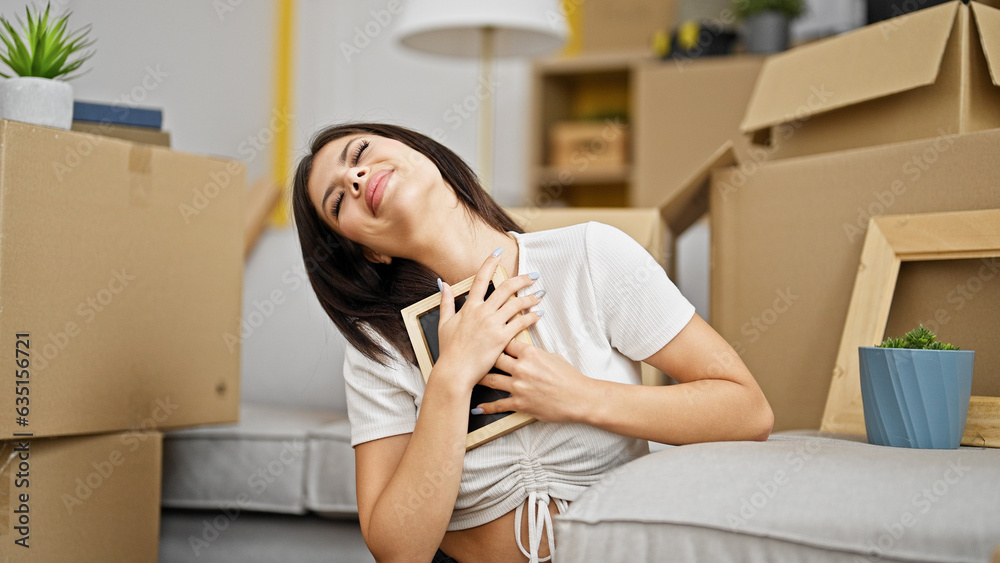 Young caucasian woman hugging photo at new home Young caucasian woman hugging photo at new home