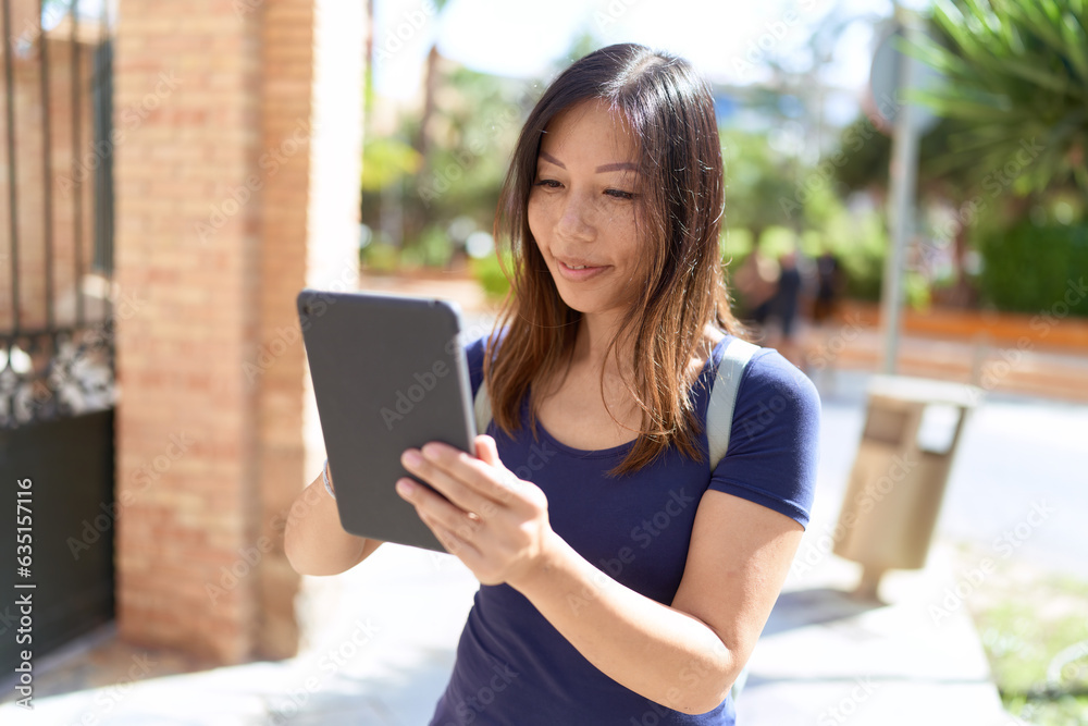 Young asian woman smiling confident using touchpad at street Young asian woman smiling confident using touchpad at street
