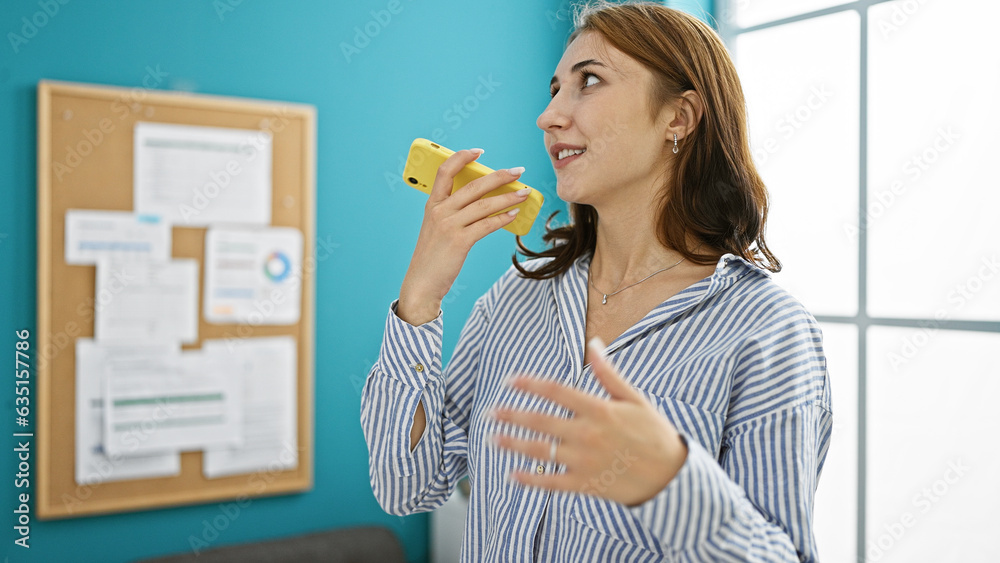 Young woman business worker sending voice message by smartphone working at the office Young woman business worker sending voice message by smartphone working at the office