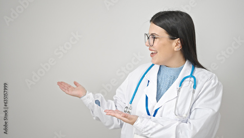 Young hispanic woman doctor smiling confident presenting over isolated white background