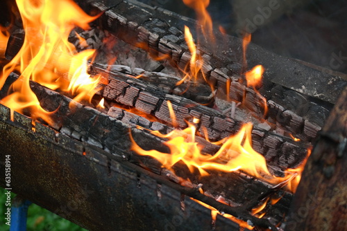 burning wood and paper. firewood is burning. tongues of flame. orange flame. bonfire. wood-fired cooking. firewood is burning for cooking barbecue