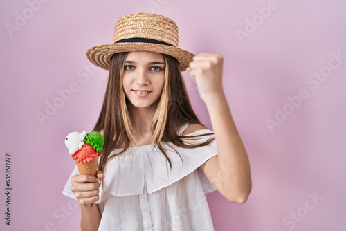 Teenager girl holding ice cream angry and mad raising fist frustrated and furious while shouting with anger. rage and aggressive concept.