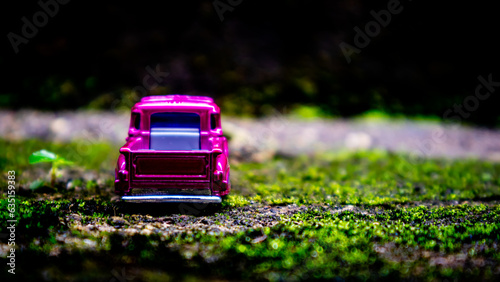 South Minahasa, Indonesia : January 2023, a toy car on a mossy floor that looks like grass photo