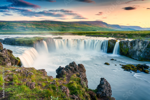 Godafoss waterfall flowing with colorful sunset sky in summer at Iceland photo