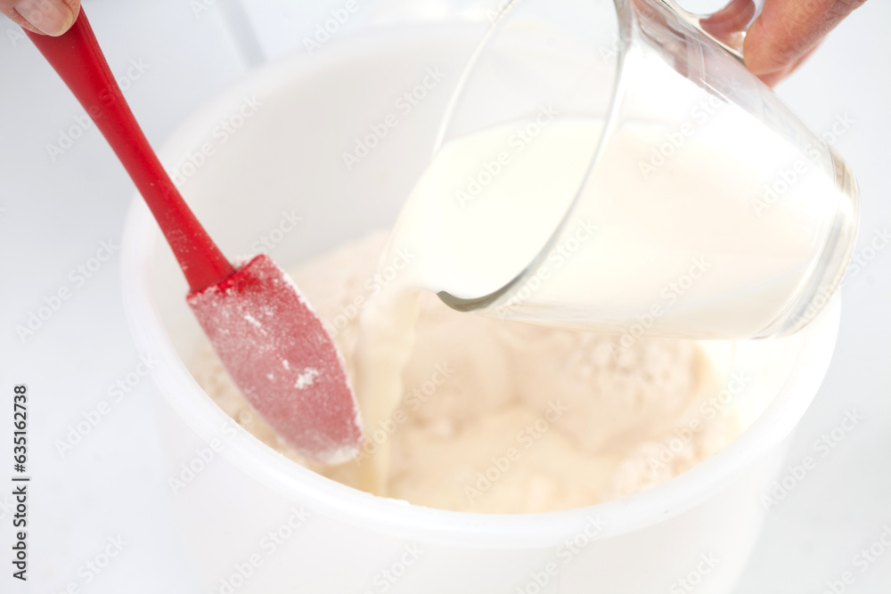 Home made pizza dough preparation. Adding milk. Pizza preparation. Home made pizza dough preparation. Adding milk. Pizza preparation.