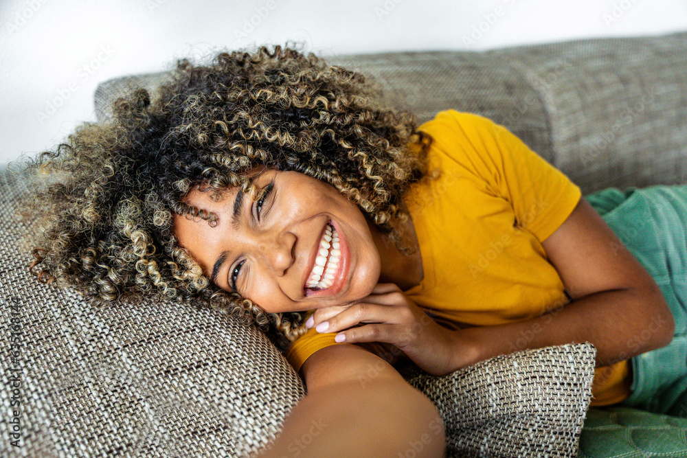 Happy afro american woman relaxing on the sofa at home - Smiling girl ...