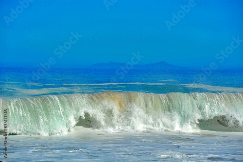  powerful cross ocean wave breaking during the day on the beach