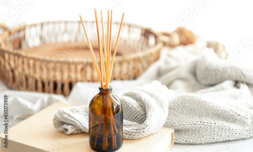 Spa composition with incense sticks and knitted element on a blurred background.