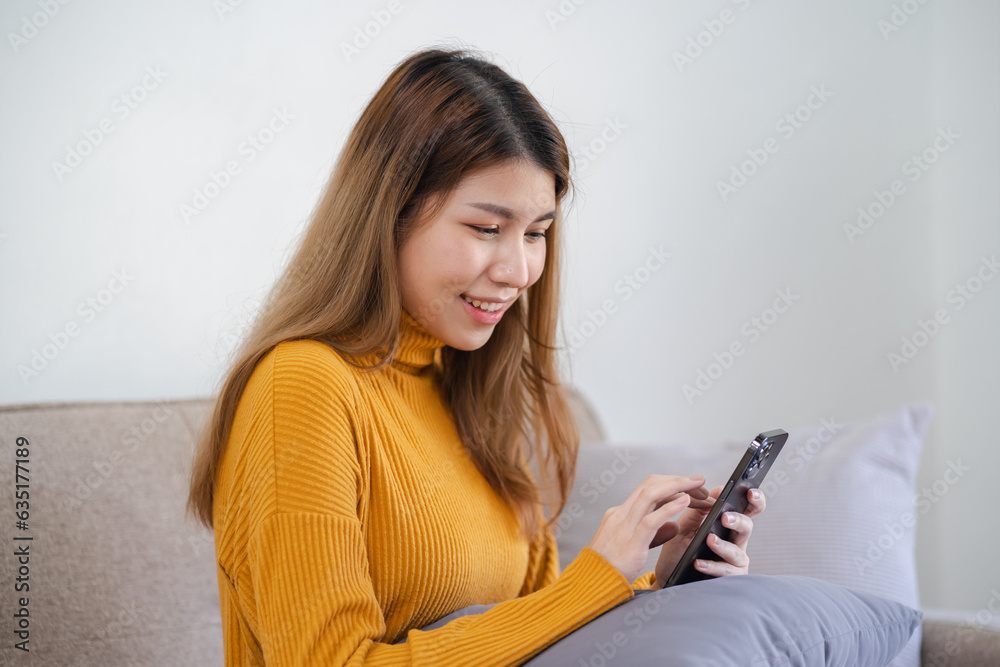Asian woman texting checking social media holding smartphone at home Conversation with boyfriend or friend. Asian woman texting checking social media holding smartphone at home Conversation with boyfriend or friend.