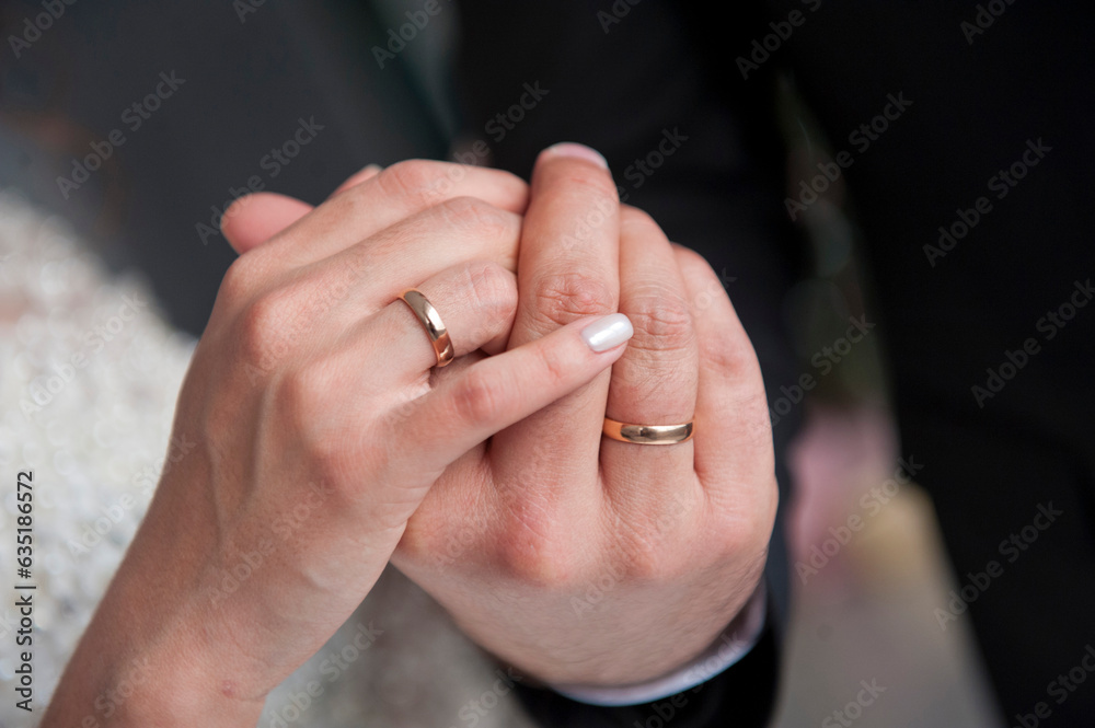 Hands of newlyweds with wedding rings