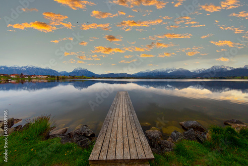 Rowing boat at dock with mountain lake, Allgäu Alps at back, blue hour, Hopfensee, Hopfen am See, Ostallgäu, Bavaria, Germany photo