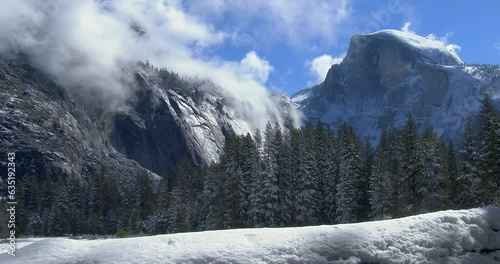 Fast clouds lift out of Yosemite Valley in front of Half Dome in winter.