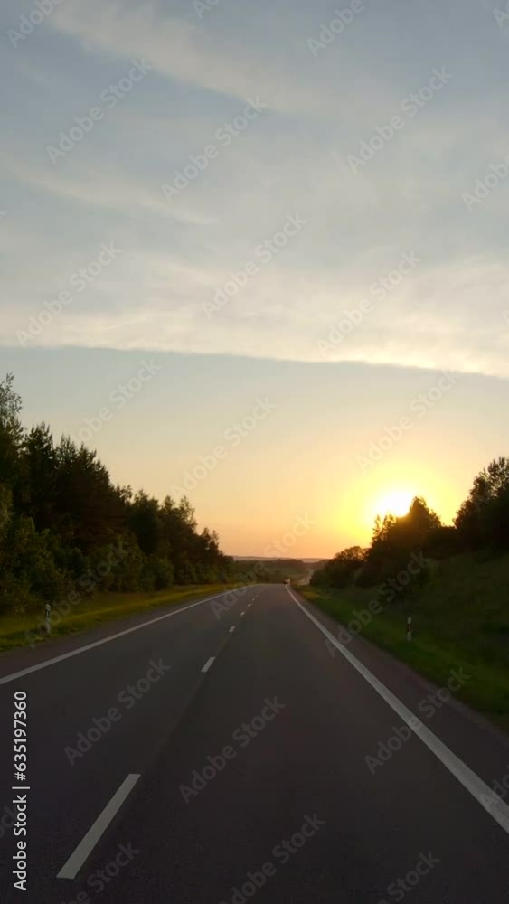 Driving along a rural road at sunset, vertical Driving along a rural road at sunset, vertical