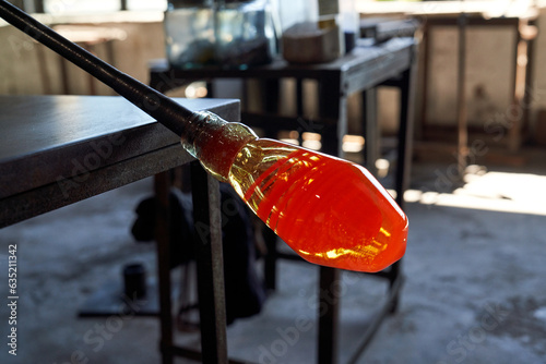 Molten glass on edge of pontil at factory photo