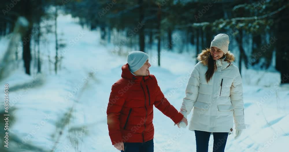 diverse man and woman in love, walking together holding hands in winter forest, 4K, Prores
