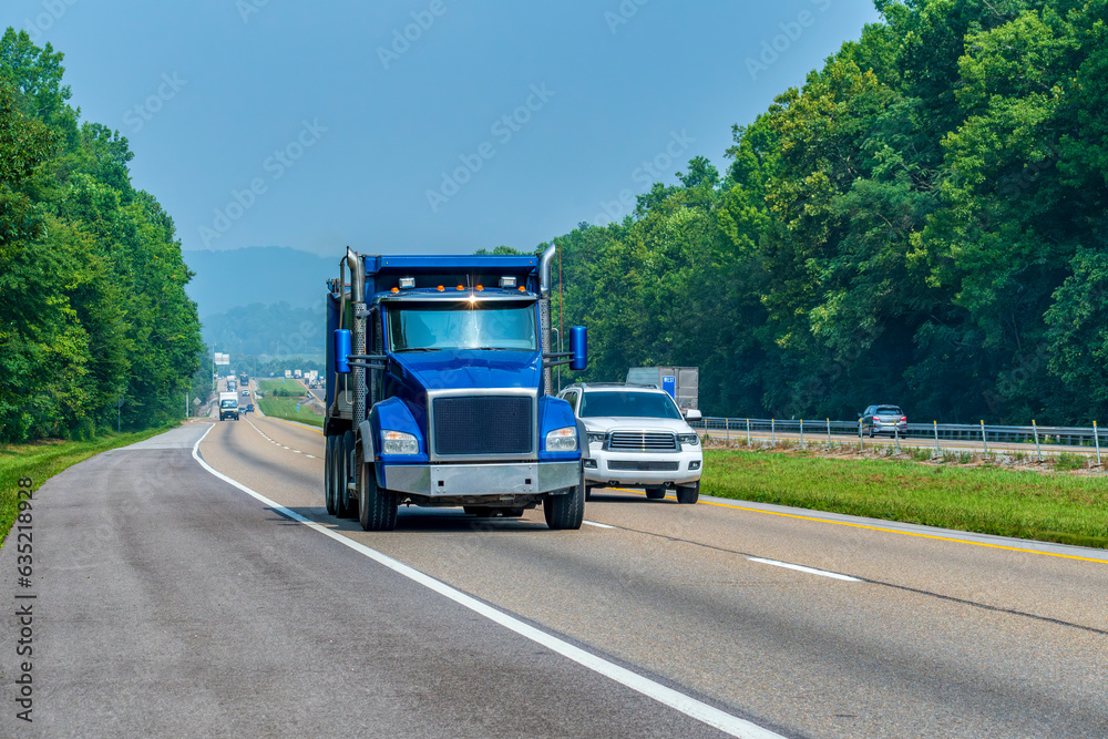 Heavy Blue Dump Truck On Interstate Highway With Copy Space