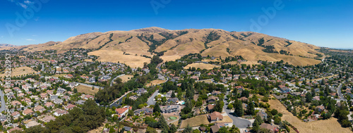 Drone photo of Mission Peak in Fremont, California on a beautiful summer day, with dead hills and houses at the base of the mountain. photo