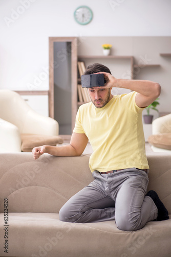 Young man enjoying virtual glasses at home
